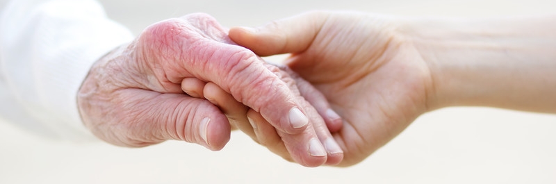 Alte und junge Hand halten sich